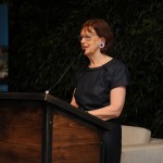 Gillian Thomas giving a speech at the Young Patrons Science Fair in the 1 Hotel