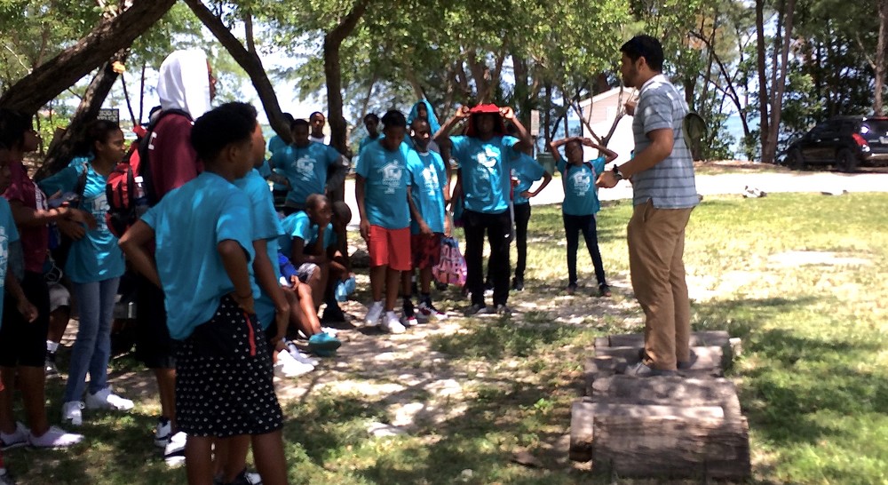 Man leading a discussion with students from the Overtown Youth Center on how to reduce, reuse and recycle.