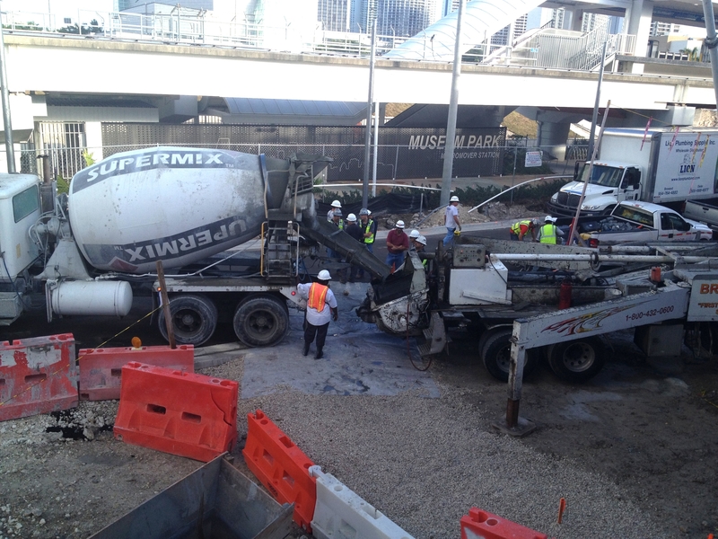 A concrete mixing truck pouring into a concrete pump, which will transport the concrete into the planetarium dome molds