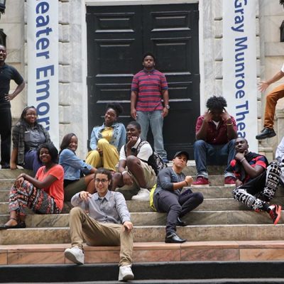 A group of Upward Bound students sits on a set of steps on a regional college tour.