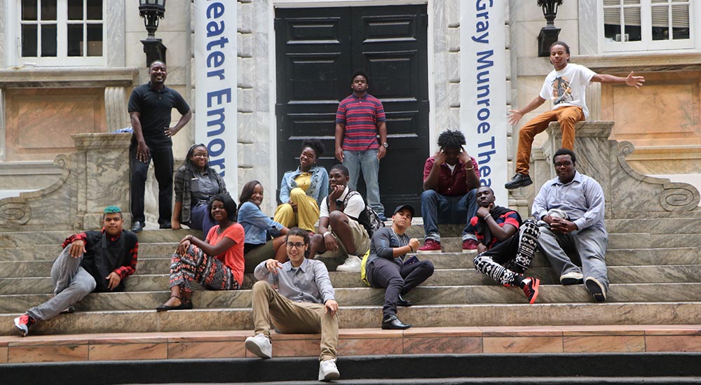 A group of Upward Bound students sits on a set of steps on a regional college tour.
