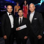 Three men posing for a photo at a gala