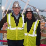 Adults posing for a photo at the construction site.