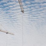 View of the sky with the tips of construction equipment