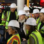 Adults posing for a photo at the construction site.