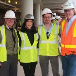 Adults posing for a photo at the construction site.