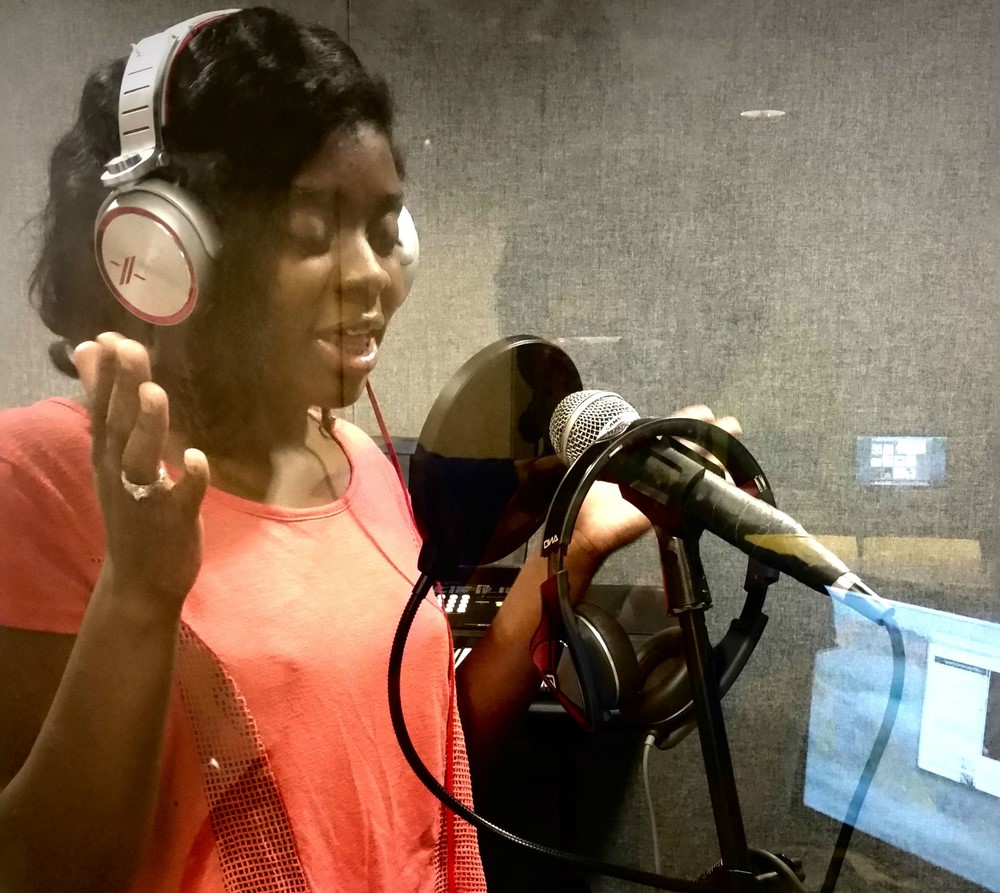 Young woman recording her original poem, “Onslaught,” on equipment provided by Best Buy.