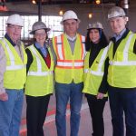 Adults posing for a photo at the construction site.