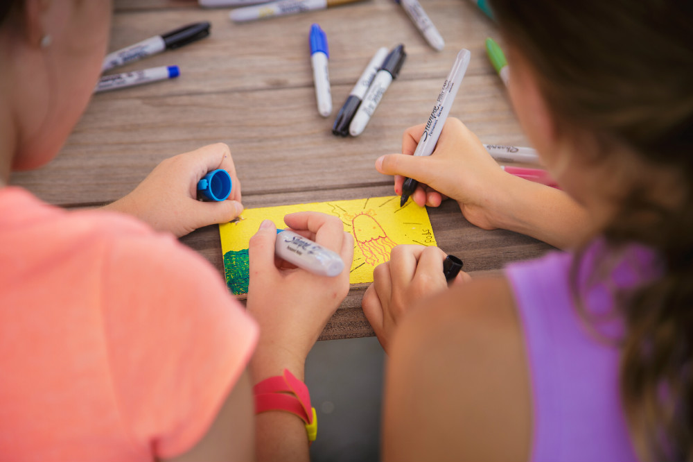 Two young girls creating an art piece