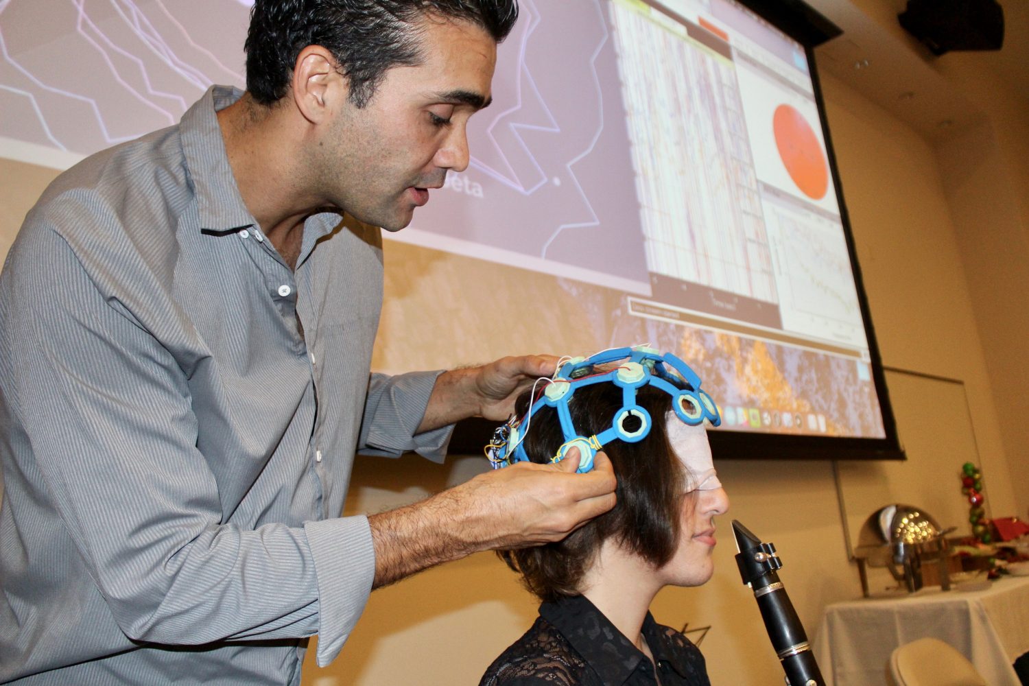 Man placing scientific equipment on woman's head