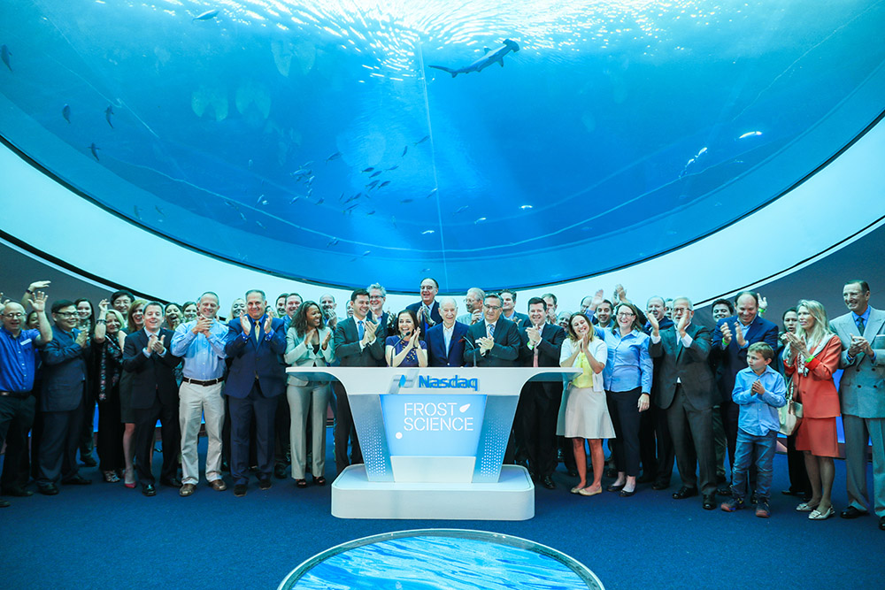 Group of adults posing for a photo in front of an aquarium