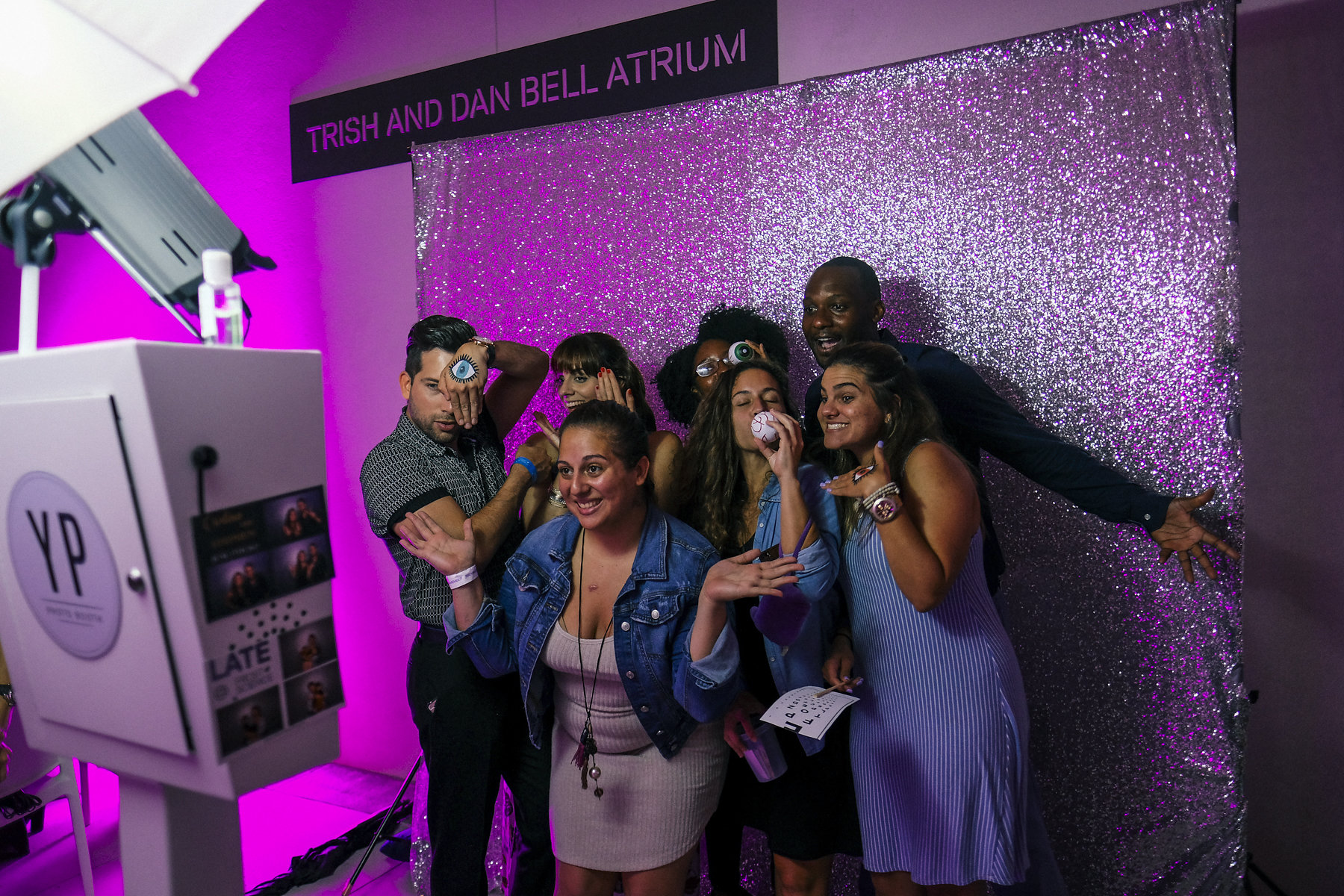 Young adults posing for a photo in a photo booth