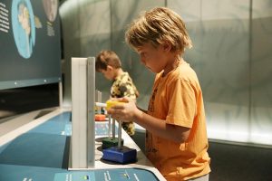 two young boys playing with a brain activity in Brain: The Inside Story exhibit.