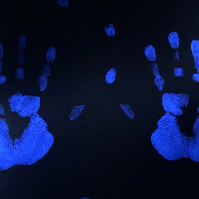 Two Glo Germ hand prints illuminated with uv light