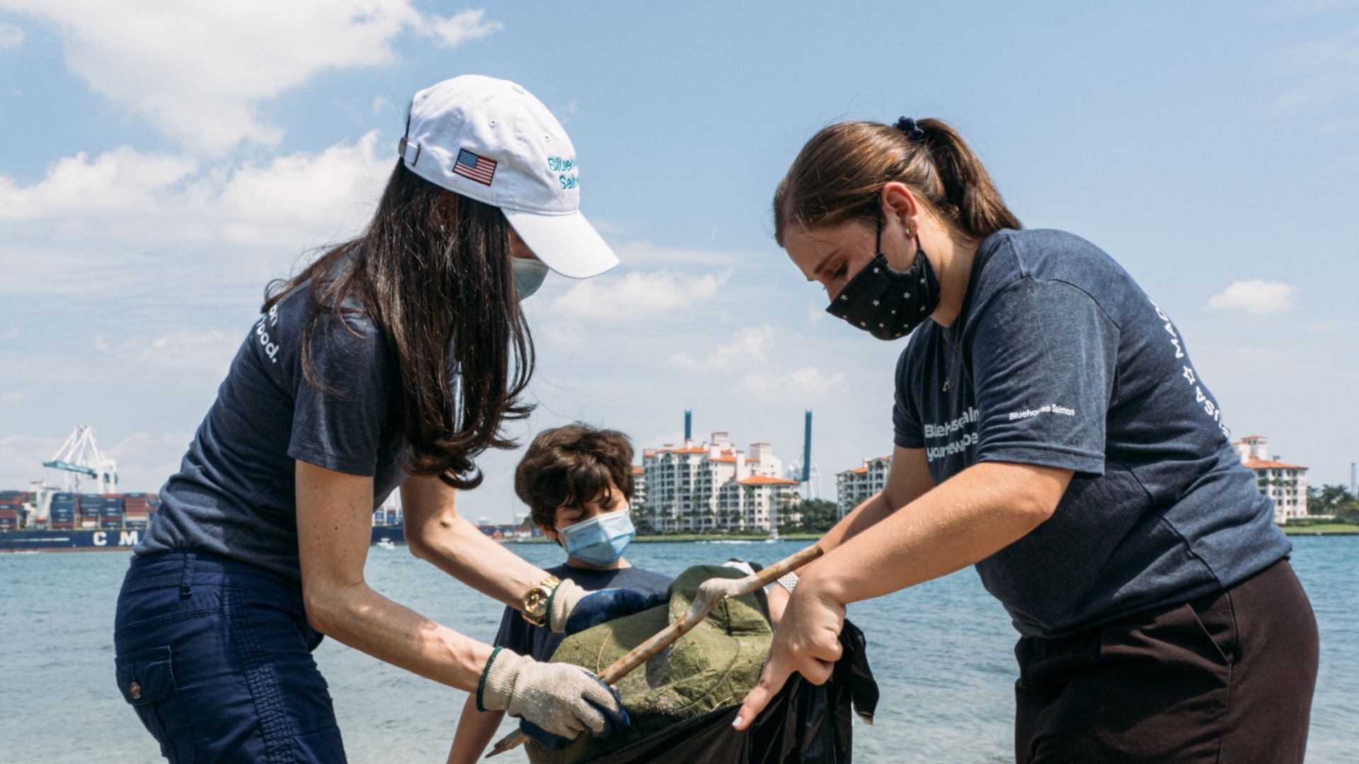 three people outdoors in coastal setting doing citizen science